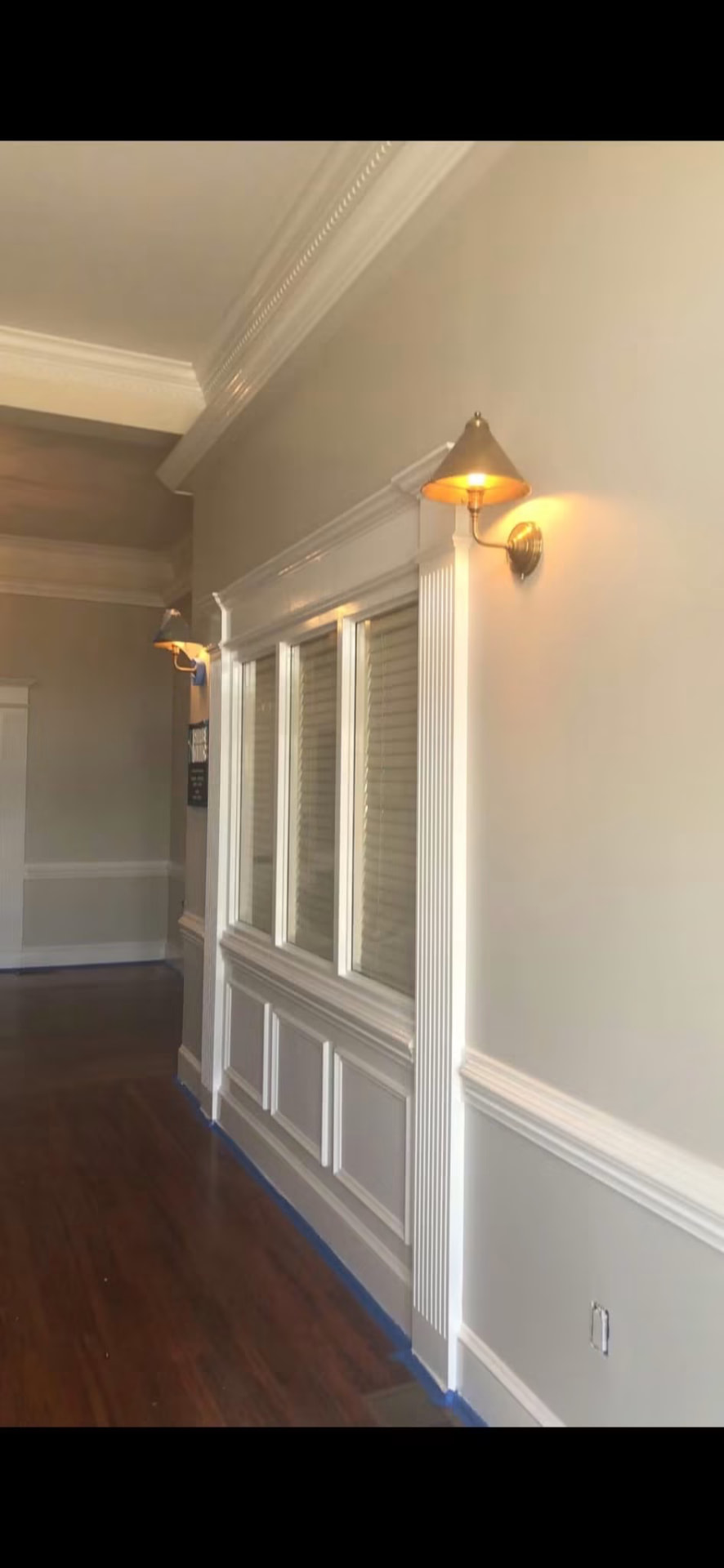 Finished hallway with crown molding, wainscoting and hardwood floors