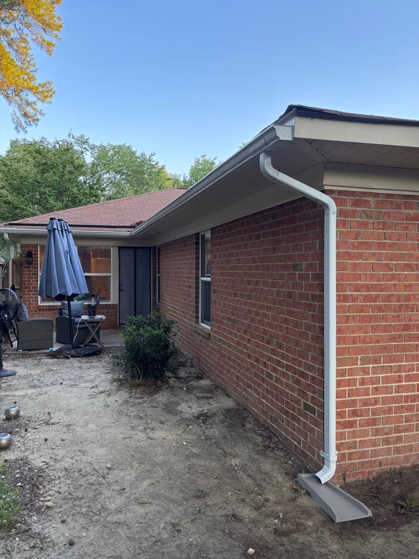 New seamless gutter and downspout installation on a brick home