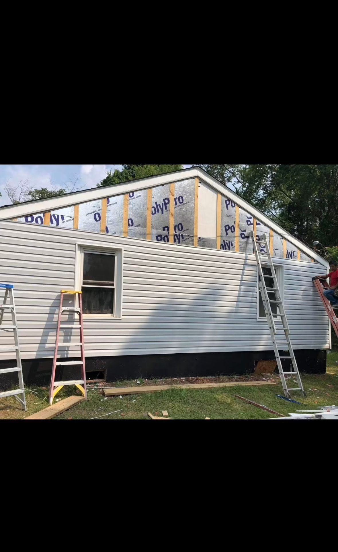 New vinyl siding and insulation board installed on an exterior wall